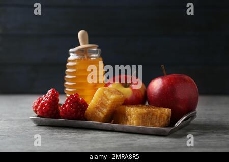 Miel, pommes et grenade sur table grise. Vacances de Rosh Hashanah Banque D'Images