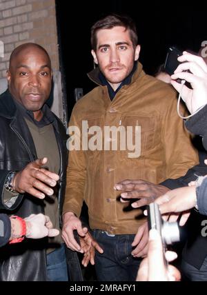 Guidé par des gardes du corps, l'acteur Jake Gyllenhaal arrive à l'Apple Store de Soho à une foule de fans. Gyllenhaal a fait l'apparition dans le magasin pour promouvoir son nouveau thriller « Source Code », qui a été publié aujourd'hui. New York, NY. 4/1/11. Banque D'Images