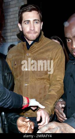 Guidé par des gardes du corps, l'acteur Jake Gyllenhaal arrive à l'Apple Store de Soho à une foule de fans. Gyllenhaal a fait l'apparition dans le magasin pour promouvoir son nouveau thriller « Source Code », qui a été publié aujourd'hui. New York, NY. 4/1/11. Banque D'Images