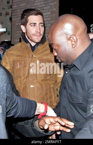 Guidé par des gardes du corps, l'acteur Jake Gyllenhaal arrive à l'Apple Store de Soho à une foule de fans. Gyllenhaal a fait l'apparition dans le magasin pour promouvoir son nouveau thriller « Source Code », qui a été publié aujourd'hui. New York, NY. 4/1/11. Banque D'Images