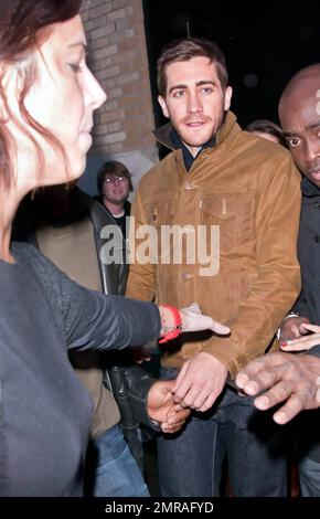 Guidé par des gardes du corps, l'acteur Jake Gyllenhaal arrive à l'Apple Store de Soho à une foule de fans. Gyllenhaal a fait l'apparition dans le magasin pour promouvoir son nouveau thriller « Source Code », qui a été publié aujourd'hui. New York, NY. 4/1/11. Banque D'Images