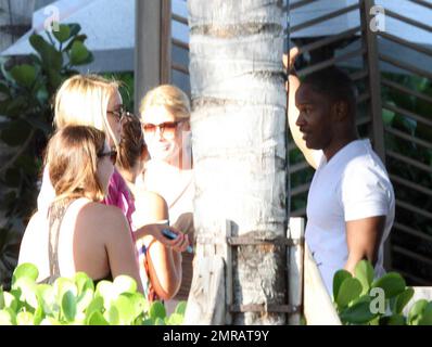 EXCLUSIF !! L'acteur Jamie Foxx a eu ses amis en point de vue lorsqu'il a bavardé avec eux au bord de la piscine dans son hôtel de luxe, avec sa petite amie l'actrice Leila Arcieri, qui portait un haut rayé brillant et un short en denim sur un bikini, à ses côtés. La quartette d'amis, qui semblait juste rencontrer Arcieri, tous ont applaudi et ont fait boire un verre rapide avant de continuer. Avant de se rendre sur leur chemin, Foxx, qui semblait confortable dans un ensemble blanc de vestes, shorts et baskets, a joué au frais et s'est arrêté pour prendre des photos avec plusieurs fans, dont deux étaient de jolies jeunes femmes qu'il a semblé à l'humour comme il a cha Banque D'Images