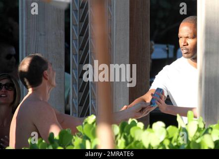 EXCLUSIF !! L'acteur Jamie Foxx a eu ses amis en point de vue lorsqu'il a bavardé avec eux au bord de la piscine dans son hôtel de luxe, avec sa petite amie l'actrice Leila Arcieri, qui portait un haut rayé brillant et un short en denim sur un bikini, à ses côtés. La quartette d'amis, qui semblait juste rencontrer Arcieri, tous ont applaudi et ont fait boire un verre rapide avant de continuer. Avant de se rendre sur leur chemin, Foxx, qui semblait confortable dans un ensemble blanc de vestes, shorts et baskets, a joué au frais et s'est arrêté pour prendre des photos avec plusieurs fans, dont deux étaient de jolies jeunes femmes qu'il a semblé à l'humour comme il a cha Banque D'Images