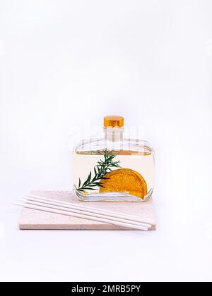 Diffuseur en roseau avec cannelle et orange sur fond blanc. Photo de haute qualité Banque D'Images