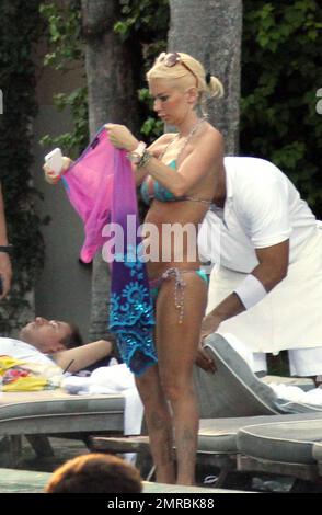 L'ancienne star de cinéma pour adultes Jenna Jameson et son mari Tito Ortiz partagent quelques moments sensibles au bord de la piscine dans leur hôtel de luxe au coucher du soleil. Le maillot Jenna semble essayer d'attirer l'attention de Tito sur son bas en pointant comme Tito regarda et placé une main sur sa hanche. Miami Beach, Floride. 12 août 2011. Banque D'Images