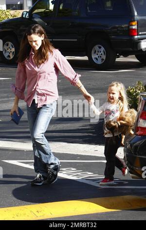 Jennifer Garner, maman qui se déporte, passe la journée avec sa fille Violet en remorquage. Le Garner vêtu de façon décontractée tient la main de Violet comme le jeune porte certaines de ses poupées comme compagnie. Los Angeles, Californie. 11/15/09. Banque D'Images