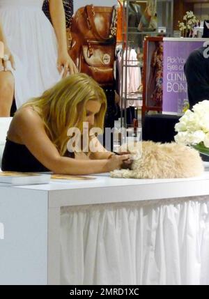 Jessica Simpson, chanteuse et entrepreneur, signe des autographes pour les fans dans un grand magasin Dilliards. Au cours de la session, Jessica avait l'air belle dans une robe noire et a passé un certain temps avec un chien qui a posé sur la table à côté d'elle pour une partie de l'événement. Scottsdale, Arizona. 3/21/09. Banque D'Images