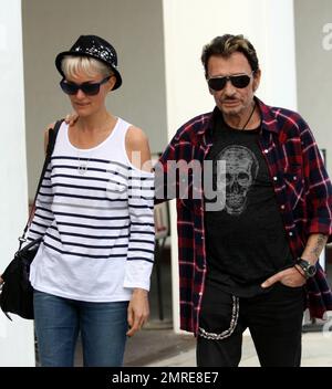 Johnny Hallyday, chanteur et acteur français, se déroule avec sa femme Laeticia Boudou après avoir déjeuné ensemble à E Baldi. Los Angeles, Californie. 4/5/11. Banque D'Images