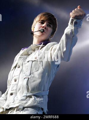 Dans une veste à boucle blanche, un Jean blanc tendance et ses sneakers montantes violet de marque Justin Bieber, un adolescent heartthrob, se produit en concert à l'American Airlines Arena. Bieber a lancé quelques mouvements de danse amusants et a semblé être droit dans ses chansons. Plus tôt dans la journée, la chanteuse canadienne avait été repérée en train de faire une promenade avec son collègue Selena Gomez. Miami, Floride. 12/18/10. Banque D'Images