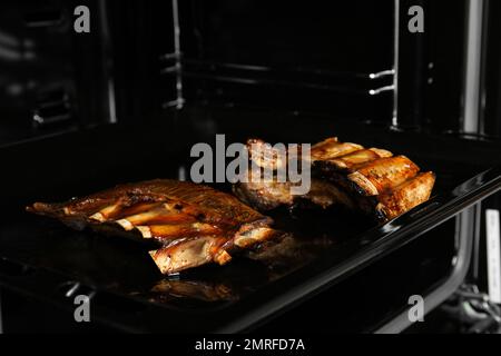 De délicieuses côtes grillées sur une plaque de cuisson au four Banque D'Images