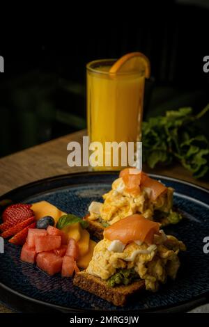 Une dose verticale de toasts aux omelettes avec du saumon et des fruits Banque D'Images