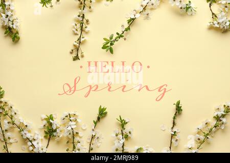 Belles branches fleuris et texte BONJOUR, PRINTEMPS sur fond beige Banque D'Images