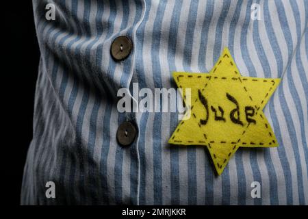 Prisonnier juif avec badge jaune sur fond sombre, gros plan. Journée internationale de commémoration de l'Holocauste Banque D'Images