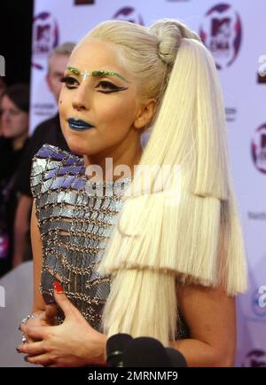 Dans une tenue tendance typique ornée d'sourcils verts étincelants, d'une croix argentée au-dessus de son nez, d'un rouge à lèvres bleu et d'une coiffure multi-couches, Lady Gaga présente ses multiples récompenses remportées aux MTV Europe Music Awards 2011 à l'Odyssey Arena de Belfast, en Irlande du Nord. 6th novembre 2011. Banque D'Images