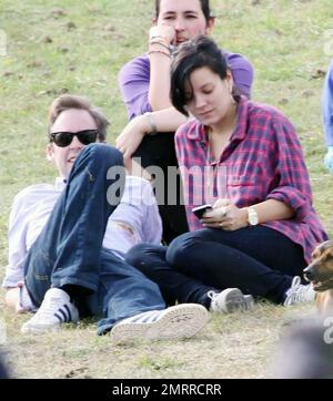 EXCLUSIF !! Premières photos de la chanteuse pop enceinte Lily Allen au Big Chill Festival avec le petit ami Sam Cooper et son chien adopté Honey. Le couple, qui vient d'annoncer qu'ils ont leur premier enfant ensemble, décontracté sur l'herbe tandis que Lily a vérifié son téléphone cellulaire. Allen est sur le point de jouer la garniture de pavillon ce soir pendant le festival de musique de week-end qui s'est tenu à Eastnor Castle Deer Park près de Ledbury, probablement l'un de ses derniers concerts avant qu'elle ne prenne une pause pour devenir mère. Herefordshire, Royaume-Uni. 08/08/10 . Banque D'Images