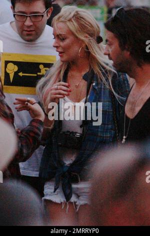 EXCLUSIF !! Dans une paire de shorts en denim de coupure et une actrice en tissu écossais, Lindsay Lohan, obstrue l'entrée de la zone VIP en essayant de sortir dans le mauvais sens. La sécurité a fait son retour et sa sortie au bon point. Indio, Californie 04/17/11. Banque D'Images