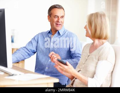 Couple d'âge mûr calculant les dépenses avec un ordinateur sur table. Portrait d'un couple mature calculant les dépenses avec un ordinateur sur table. Banque D'Images