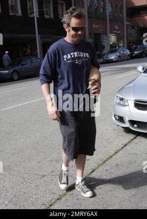 L'acteur Matthew Perry, connu pour son personnage Chandler Bing sur « Friends », a été vu quitter un bâtiment médical à L.A. L'acteur de 42 ans avait l'air un peu effrayé dans un t-shirt Patriots, un short à carreaux gris et des baskets noires, alors qu'il traversait la rue en tenant une boisson énergétique et en faisant des signes aux photographes. Los Angeles, Californie. 30th janvier 2012. Banque D'Images