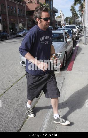 L'acteur Matthew Perry, connu pour son personnage Chandler Bing sur « Friends », a été vu quitter un bâtiment médical à L.A. L'acteur de 42 ans avait l'air un peu effrayé dans un t-shirt Patriots, un short à carreaux gris et des baskets noires, alors qu'il traversait la rue en tenant une boisson énergétique et en faisant des signes aux photographes. Los Angeles, Californie. 30th janvier 2012. Banque D'Images