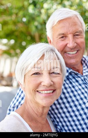 Encore heureusement marié après toutes ces années. un heureux couple senior debout ensemble à l'extérieur. Banque D'Images