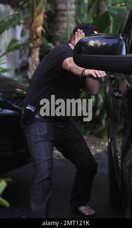 EXCLUSIF !! Michael Lohan tente de se cacher lorsqu'il quitte l'hôtel de Lindsay Lohan. Le père des actrices portait une casquette avec un coeur sur elle et essaya de couvrir son visage avec sa main pendant qu'il est parti. Il n'est pas clair s'il a effectivement réussi à rendre visite à sa fille. Quelques minutes plus tôt, Lindsay était visible à la piscine et semblait pleurer. Miami, Floride. 5/22/11. Banque D'Images