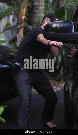 EXCLUSIF !! Michael Lohan tente de se cacher lorsqu'il quitte l'hôtel de Lindsay Lohan. Le père des actrices portait une casquette avec un coeur sur elle et essaya de couvrir son visage avec sa main pendant qu'il est parti. Il n'est pas clair s'il a effectivement réussi à rendre visite à sa fille. Quelques minutes plus tôt, Lindsay était visible à la piscine et semblait pleurer. Miami, Floride. 5/22/11. Banque D'Images