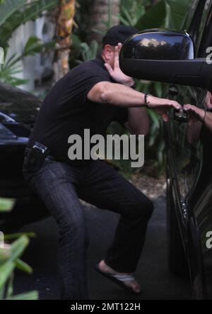 EXCLUSIF !! Michael Lohan tente de se cacher lorsqu'il quitte l'hôtel de Lindsay Lohan. Le père des actrices portait une casquette avec un coeur sur elle et essaya de couvrir son visage avec sa main pendant qu'il est parti. Il n'est pas clair s'il a effectivement réussi à rendre visite à sa fille. Quelques minutes plus tôt, Lindsay était visible à la piscine et semblait pleurer. Miami, Floride. 5/22/11. Banque D'Images