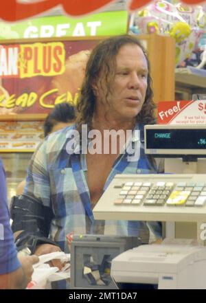 EXCLUSIF !! La star du prochain film « Iron Man 2 », nominé aux Oscars, Mickey Rourke porte un corset sur son bras alors qu'il s'arrête dans une pharmacie locale avant de se promener à Miami Beach avec sa petite amie, le modèle Anastassija Makarenko. Les deux, qui se sont rencontrés sur une séance photo et qui datent de près d'un an, ont été très affectueux lorsqu'ils se sont promenés. Miami, Floride. 4/8/10. . Banque D'Images