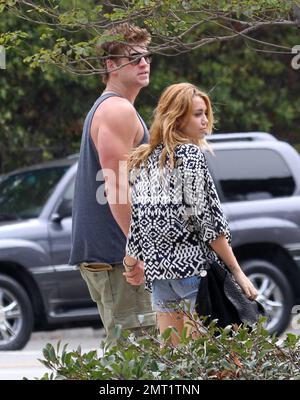 EXCLUSIF !! Miley Cyrus et son petit ami l'acteur australien Liam Hemsworth se promener dans la ville dans une voiture de sport convertible conduite par Liam avant de s'arrêter dans un centre dédié à la méditation. Le couple lovey-dovey a passé 30 minutes à l'intérieur avant de sortir le bras dans le bras et de tenir les mains. Miley, portant un short jean et un haut à coupe basse, embrassa le bras de Liam avant de rentrer dans la voiture et de se lancer dans le jour des prix Teen Choice. Los Angeles, CA 7th août 2011 Banque D'Images