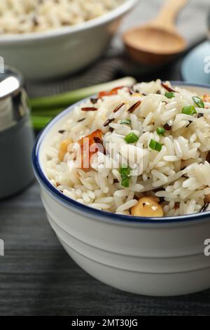 Délicieux riz pilaf avec poulet sur table en bois noir, en gros plan Banque D'Images