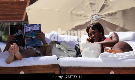 Naomi Campbell et son petit ami russe Vladislav Doronin passent la journée à la plage. La mannequin portait un bikini rouge qui montra sa figure. Miami, Floride. 10/11/09. Banque D'Images