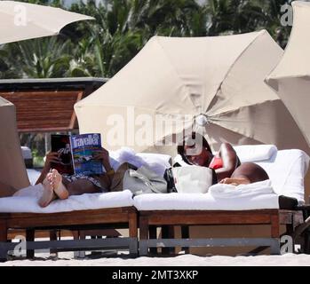 Naomi Campbell et son petit ami russe Vladislav Doronin passent la journée à la plage. La mannequin portait un bikini rouge qui montra sa figure. Miami, Floride. 10/11/09. Banque D'Images