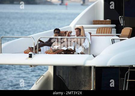 Naomi Campbell et son petit ami russe Vladislav Doronin vivent la vie de luxe de croisière dans l'eau autour de Miami sur un yacht Lazzara $10 950 000. Le couple a passé l'immense manoir qu'ils auraient acheté sur Star Island pour $16 000 000 comme ils sont allés. Le Supermodel se prélasa dans une chaise sur le dessus du double decker Angela D pendant la promenade au coucher du soleil à la maison avec son beau lourd. Miami, Floride. 10/11/09. Banque D'Images