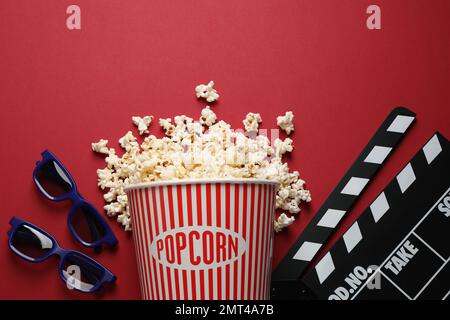 Composition de la couche plate avec délicieux pop-corn sur fond rouge Banque D'Images