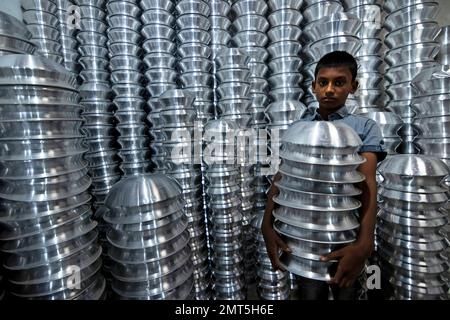 Dhaka, Dhaka, Bangladesh. 1st févr. 2023. Un enfant transporte des pots dans une usine de fabrication de pots en aluminium à Dhaka, au Bangladesh. Chacun des enfants gagne environ 80 GBP par mois travaillant plus de 12 heures par jour. De nombreux jeunes travailleurs migrent vers la ville de Dhaka pour de meilleurs emplois et vivent dans des bidonvilles. Il y a environ 1,7 millions de travailleurs de l'enfance dans le pays, dont 1,2 millions sont engagés dans des travaux dangereux. Selon la législation du travail au Bangladesh, l'âge minimum d'admission à l'emploi est de 14 ans. L'application d'une telle loi du travail est pratiquement impossible dans le pays parce que la plupart des enfants travailleurs sont employés Banque D'Images