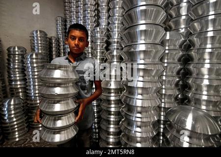 Dhaka, Dhaka, Bangladesh. 1st févr. 2023. Un enfant transporte des pots dans une usine de fabrication de pots en aluminium à Dhaka, au Bangladesh. Chacun des enfants gagne environ 80 GBP par mois travaillant plus de 12 heures par jour. De nombreux jeunes travailleurs migrent vers la ville de Dhaka pour de meilleurs emplois et vivent dans des bidonvilles. Il y a environ 1,7 millions de travailleurs de l'enfance dans le pays, dont 1,2 millions sont engagés dans des travaux dangereux. Selon la législation du travail au Bangladesh, l'âge minimum d'admission à l'emploi est de 14 ans. L'application d'une telle loi du travail est pratiquement impossible dans le pays parce que la plupart des enfants travailleurs sont employés Banque D'Images