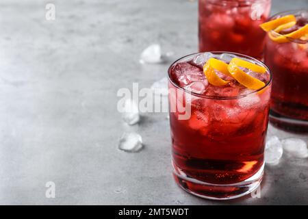 Cocktail Negroni frais avec zeste d'orange sur table grise. Espace pour le texte Banque D'Images