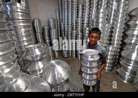 Dhaka, Dhaka, Bangladesh. 1st févr. 2023. Un enfant transporte des pots dans une usine de fabrication de pots en aluminium à Dhaka, au Bangladesh. Chacun des enfants gagne environ 80 GBP par mois travaillant plus de 12 heures par jour. De nombreux jeunes travailleurs migrent vers la ville de Dhaka pour de meilleurs emplois et vivent dans des bidonvilles. Il y a environ 1,7 millions de travailleurs de l'enfance dans le pays, dont 1,2 millions sont engagés dans des travaux dangereux. Selon la législation du travail au Bangladesh, l'âge minimum d'admission à l'emploi est de 14 ans. L'application d'une telle loi du travail est pratiquement impossible dans le pays parce que la plupart des enfants travailleurs sont employés Banque D'Images