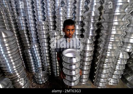 Dhaka, Dhaka, Bangladesh. 1st févr. 2023. Un enfant transporte des pots dans une usine de fabrication de pots en aluminium à Dhaka, au Bangladesh. Chacun des enfants gagne environ 80 GBP par mois travaillant plus de 12 heures par jour. De nombreux jeunes travailleurs migrent vers la ville de Dhaka pour de meilleurs emplois et vivent dans des bidonvilles. Il y a environ 1,7 millions de travailleurs de l'enfance dans le pays, dont 1,2 millions sont engagés dans des travaux dangereux. Selon la législation du travail au Bangladesh, l'âge minimum d'admission à l'emploi est de 14 ans. L'application d'une telle loi du travail est pratiquement impossible dans le pays parce que la plupart des enfants travailleurs sont employés Banque D'Images