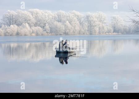 Pêcheurs de la pêche du brochet du Nord (Esox lucius) à partir du bateau Whitlingham à Frost CP Norfolk UK GB janvier 2023 Banque D'Images