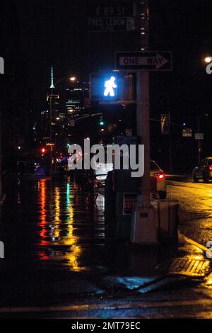 Une photo verticale de la rue avec une lumière piétonne lors d'une nuit de pluie. New York, États-Unis. Banque D'Images