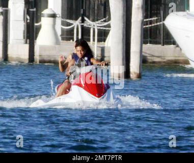 Les fils de Sean P Diddy Combs Quincy et Justin jouent sur des motomarines près de la maison de leur père en bord de mer avec quelques compagnons féminins. Le plus jeune des deux a été tiré par un bateau de police de Miami peut-être pour aller trop vite après que Diddy avait reculé à l'intérieur. D'autres clients, dont Janice Combs, la mère de Diddy, se détendent sur le quai en admirant le coucher du soleil. Miami Beach, FL, 11/28/09. Banque D'Images