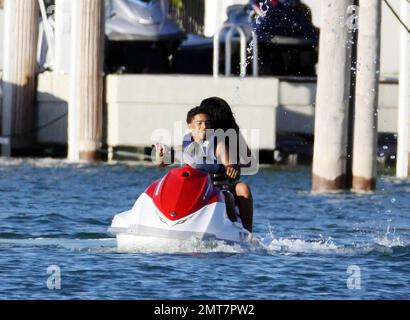 Les fils de Sean P Diddy Combs Quincy et Justin jouent sur des motomarines près de la maison de leur père en bord de mer avec quelques compagnons féminins. Le plus jeune des deux a été tiré par un bateau de police de Miami peut-être pour aller trop vite après que Diddy avait reculé à l'intérieur. D'autres clients, dont Janice Combs, la mère de Diddy, se détendent sur le quai en admirant le coucher du soleil. Miami Beach, FL, 11/28/09. Banque D'Images