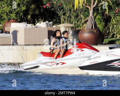 Les fils de Sean P Diddy Combs Quincy et Justin jouent sur des motomarines près de la maison de leur père en bord de mer avec quelques compagnons féminins. Le plus jeune des deux a été tiré par un bateau de police de Miami peut-être pour aller trop vite après que Diddy avait reculé à l'intérieur. D'autres clients, dont Janice Combs, la mère de Diddy, se détendent sur le quai en admirant le coucher du soleil. Miami Beach, FL, 11/28/09. Banque D'Images