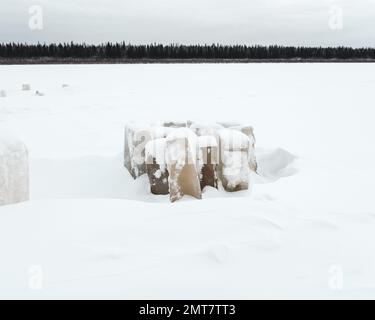 Glace sculptée pour manger des piliers couverts de neige en tas sur la rivière Vilyui à Yakutia en hiver, sur fond d'une forêt de taïga. Banque D'Images