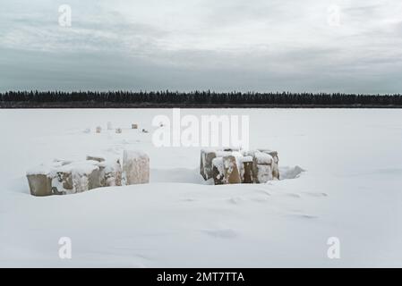 Glace sculptée pour manger des piliers couverts de neige en tas sur la rivière Vilyui à Yakutia en hiver, sur fond d'une forêt de taïga. Banque D'Images