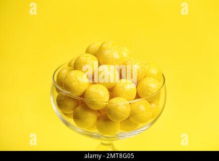 Gommes à mâcher au citron savoureuses en verre sur fond jaune Banque D'Images