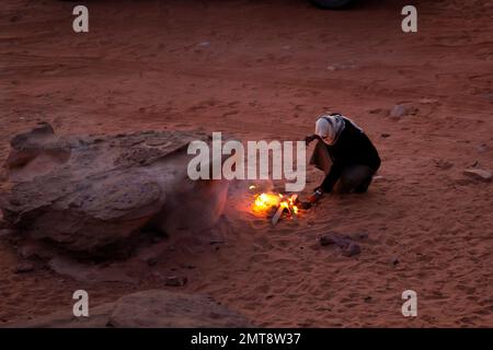 Jordanie, Wadi Rum - 1 novembre 2022: L'homme bédouin prépare le thé traditionnel jordanien au feu Banque D'Images