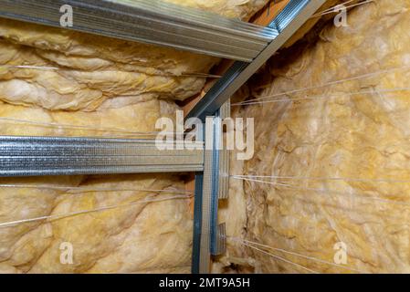 Cadre en aluminium avec des cintres placés sur des poutres dans le grenier pour le montage de placoplâtre. Banque D'Images