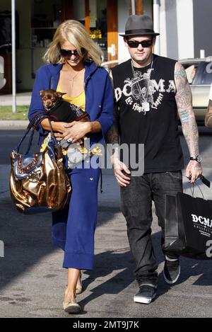 Une de ces choses n'est pas comme les autres! Paris Hilton, avec son petit chien en panne, semble un peu hors de place avec sa tenue colorée et son gros chapeau bleu alors qu'elle et son petit ami Benji Madden font un arrêt pour faire du shopping au magasin Benji, DCMA collective. Hollywood, Californie. 5/20/08. Banque D'Images